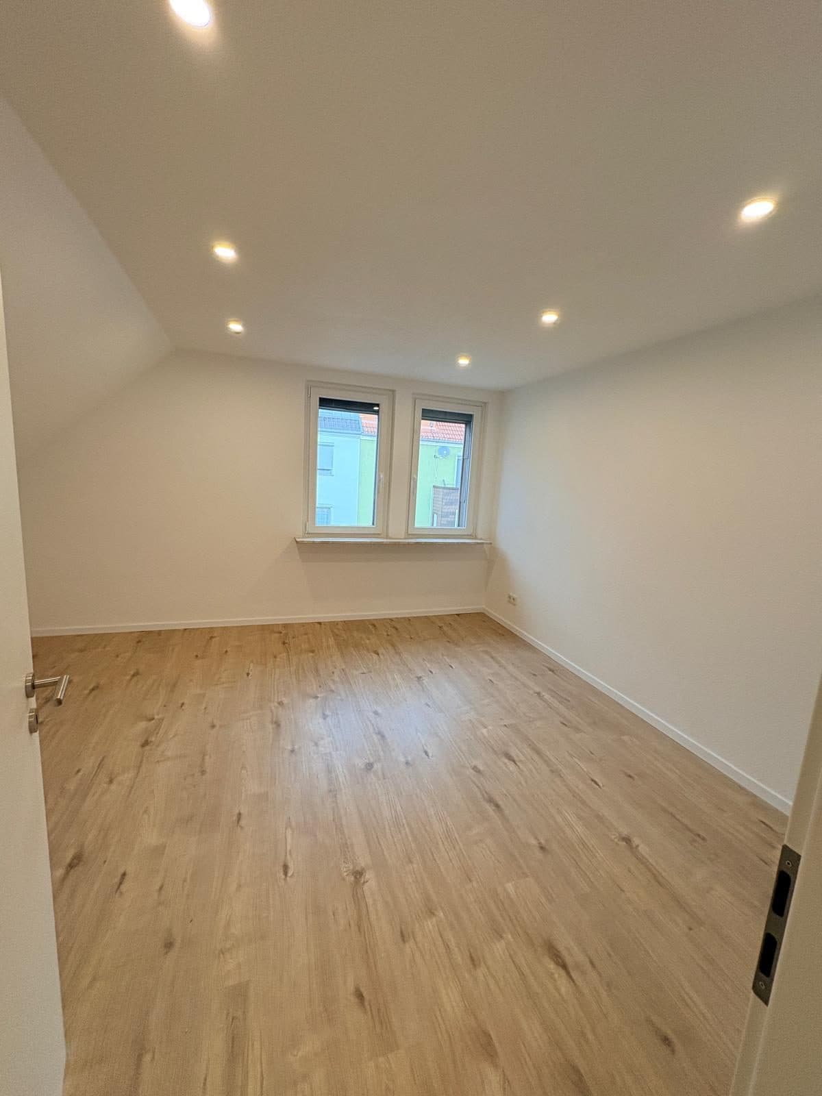 Dasselbe Dachzimmer nach der Sanierung mit hellem Holzboden