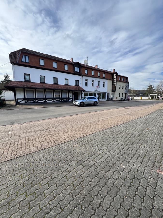 Langgestrecktes Wohn- und Geschäftshaus mit Mansarddach und Gewerbeeinheit im Erdgeschoss